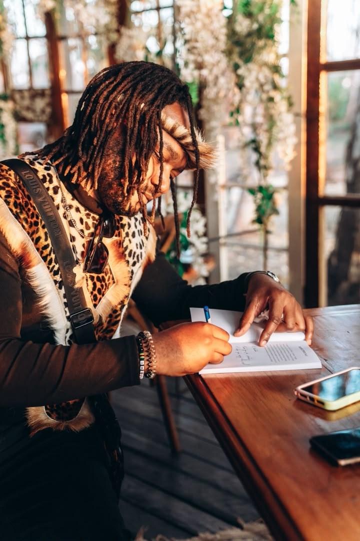 Dr. Phillip Tinashe Gwatidzo signing a copy of his work